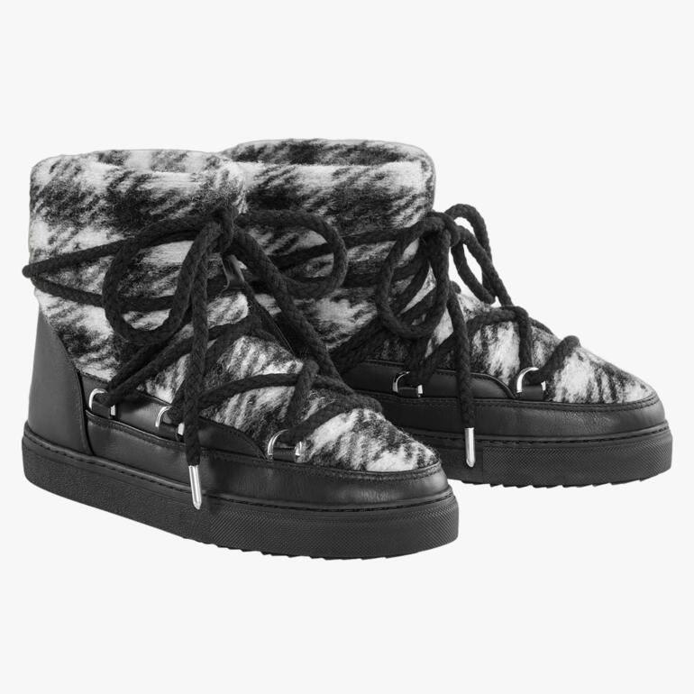 Bottes Inuikii en peau de mouton, présentées par paire, avec un matériau robuste et des lacets.