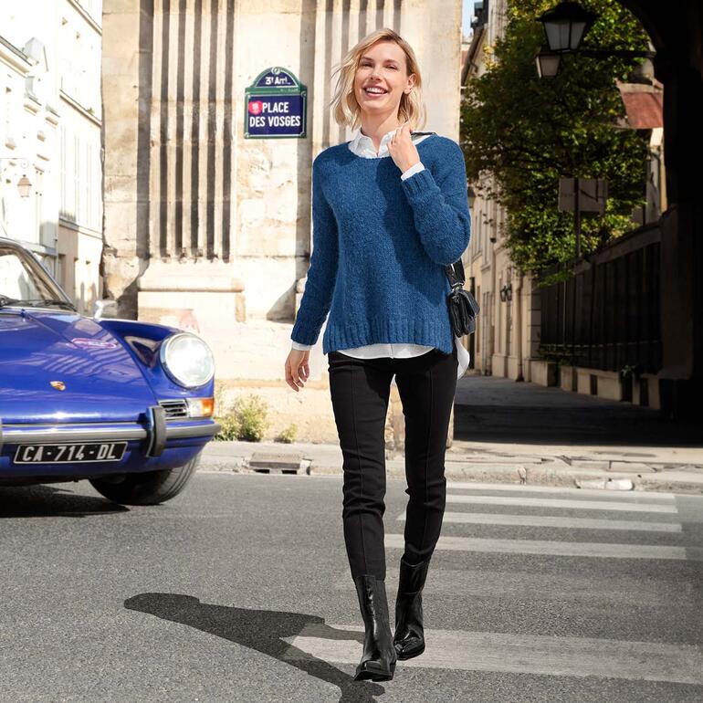 Bottines Western Laura Bellariva Femme en pull bleu dans la rue avec des bâtiments historiques.