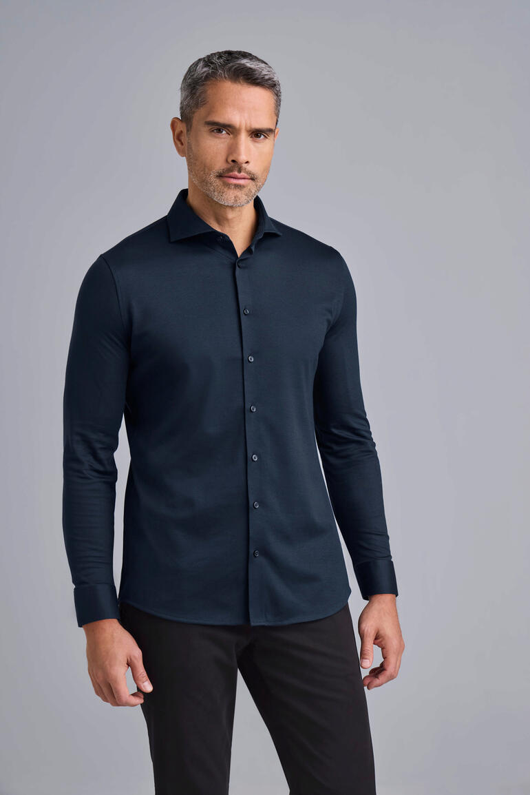 Chemise en jersey Desoto Homme en chemise jersey noire Desoto devant un fond gris.