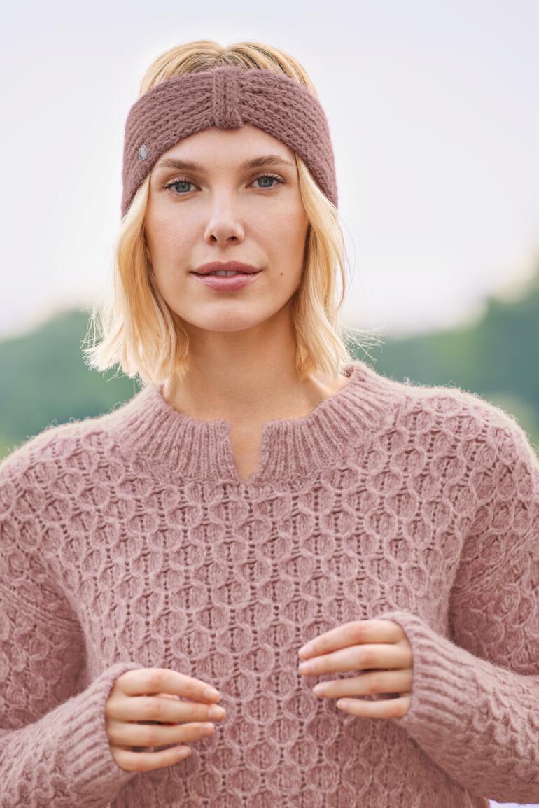 Baie Femme avec un bandeau en alpaga rose et un pull en tricot.