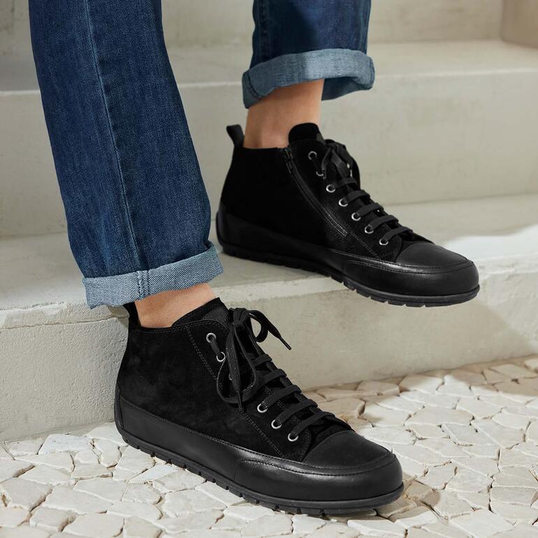 Baskets montantes noires en daim avec lacets, portées avec un jean.