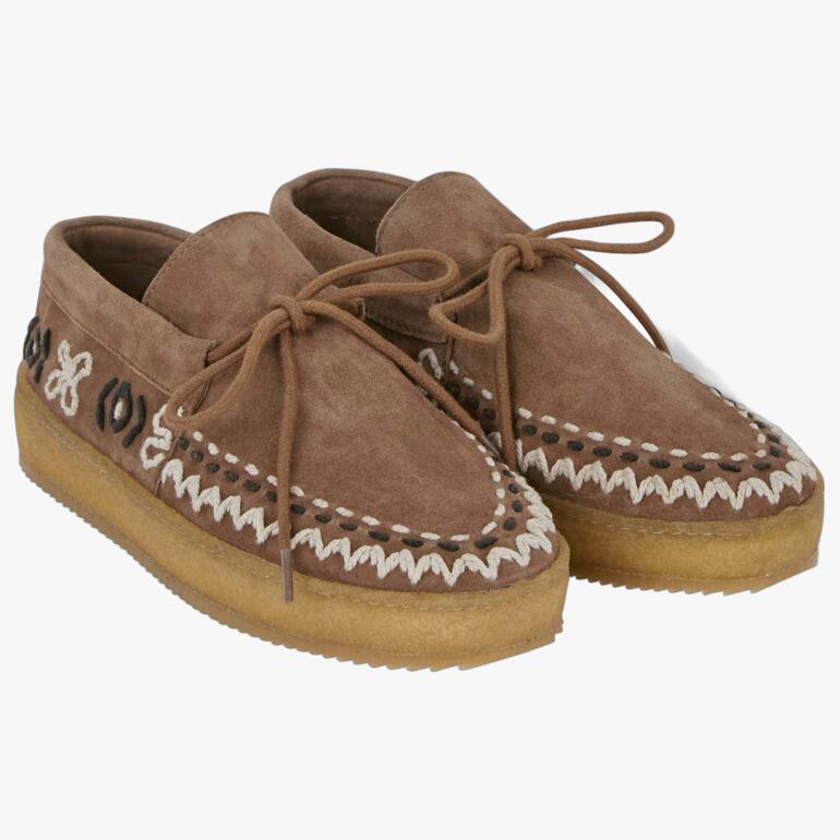 Deux mocassins boho marron côte à côte, avec lacets et motifs.