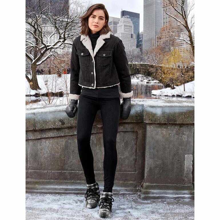 Jean sculptant 3D Liu Jo Jeans Femme en jeans 3D shaping avec une veste noire et des gants chauds dans un paysage urbain d'hiver.