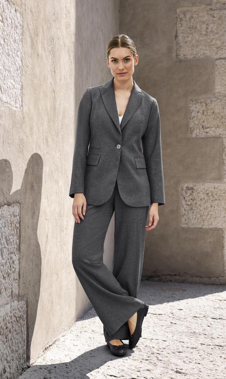 Femme en blazer et pantalon gris dans la rue