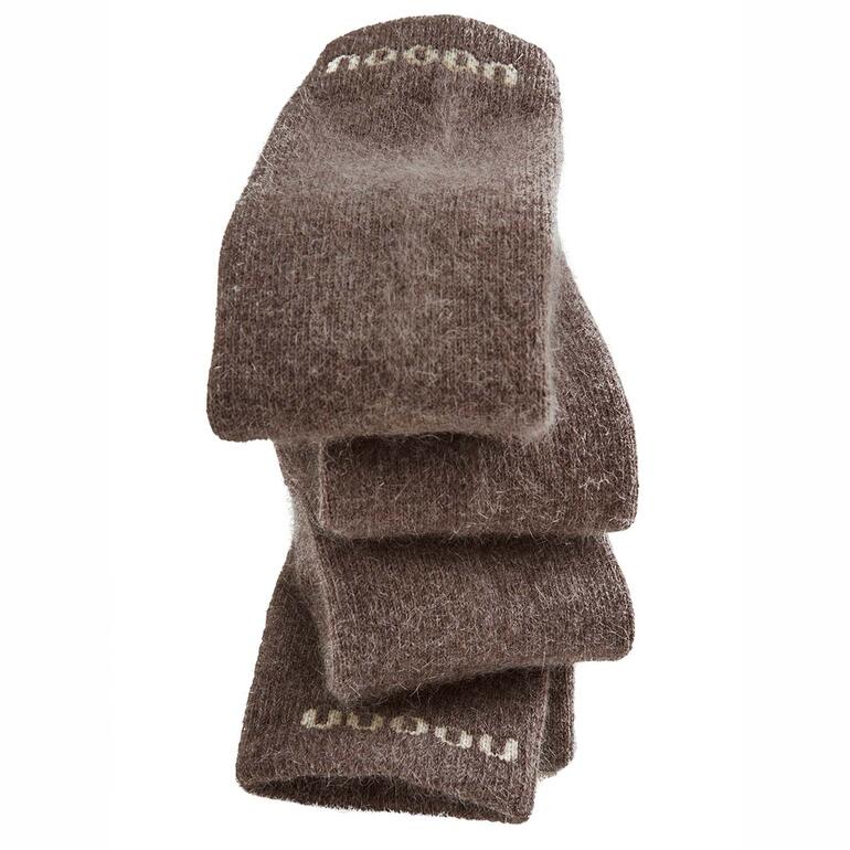 Tas de chaussettes unisexes brunes en matériau doux dans une lumière douce.