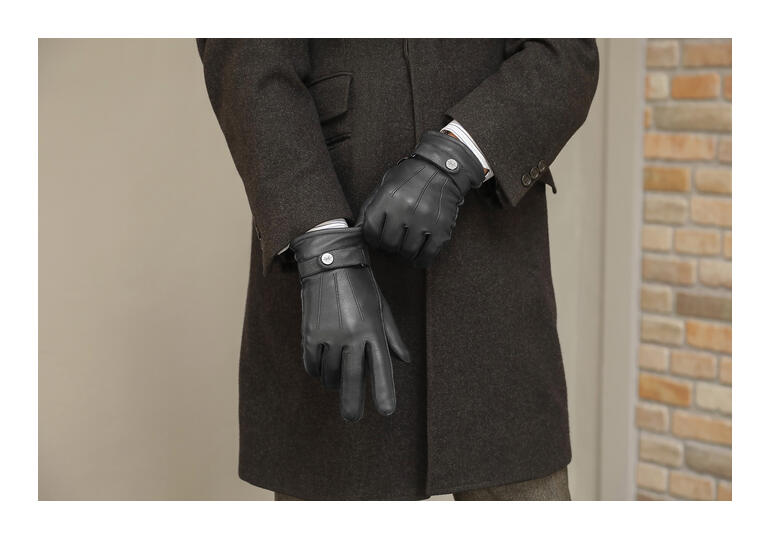 Homme portant des gants en cuir de cerf noirs avec un manteau d'hiver élégant.