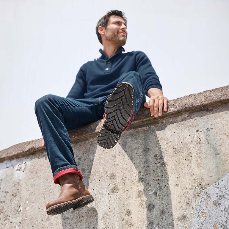 Bottines workwear Labuta Homme assis sur un mur en troyer outdoor, regardant vers le haut