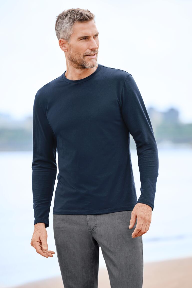 Homme, Marine Homme portant un t-shirt en cachemire Junghans 1954 sur la plage.