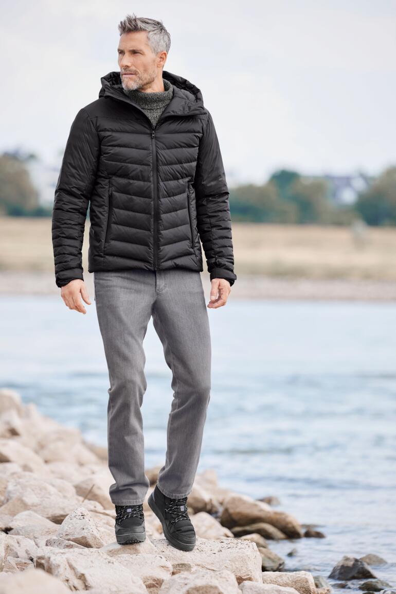 Veste de pluie en duvet Homme en veste de pluie en duvet, debout à l'eau et souriant.
