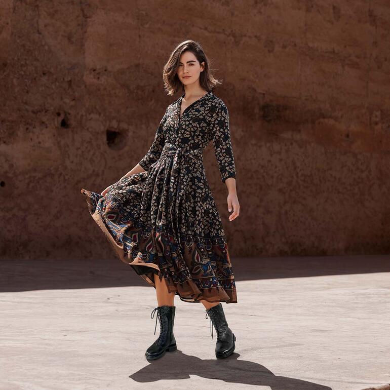 Bottines à lacet Cordwainer Femme en robe en laine à motif floral effectuant un mouvement tournant.
