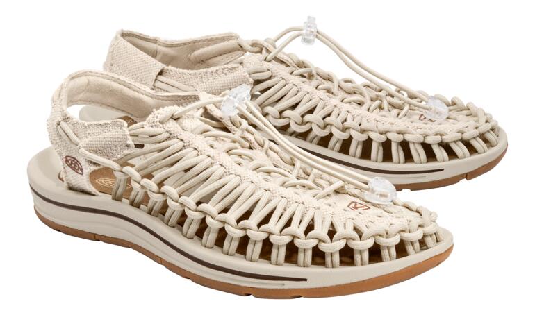 Une paire de sandales Uneek de KEEN en couleur naturelle sur fond blanc.