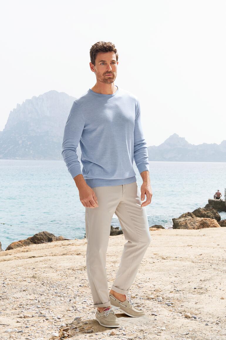 Pantalon chino confortable Brax Homme en chinos confortables et pull au bord de la mer.