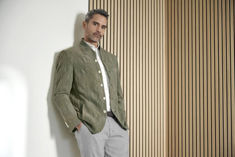 Veste en jacquard Hartwich Homme portant une veste Jacquard Hartwich dans un espace moderne.