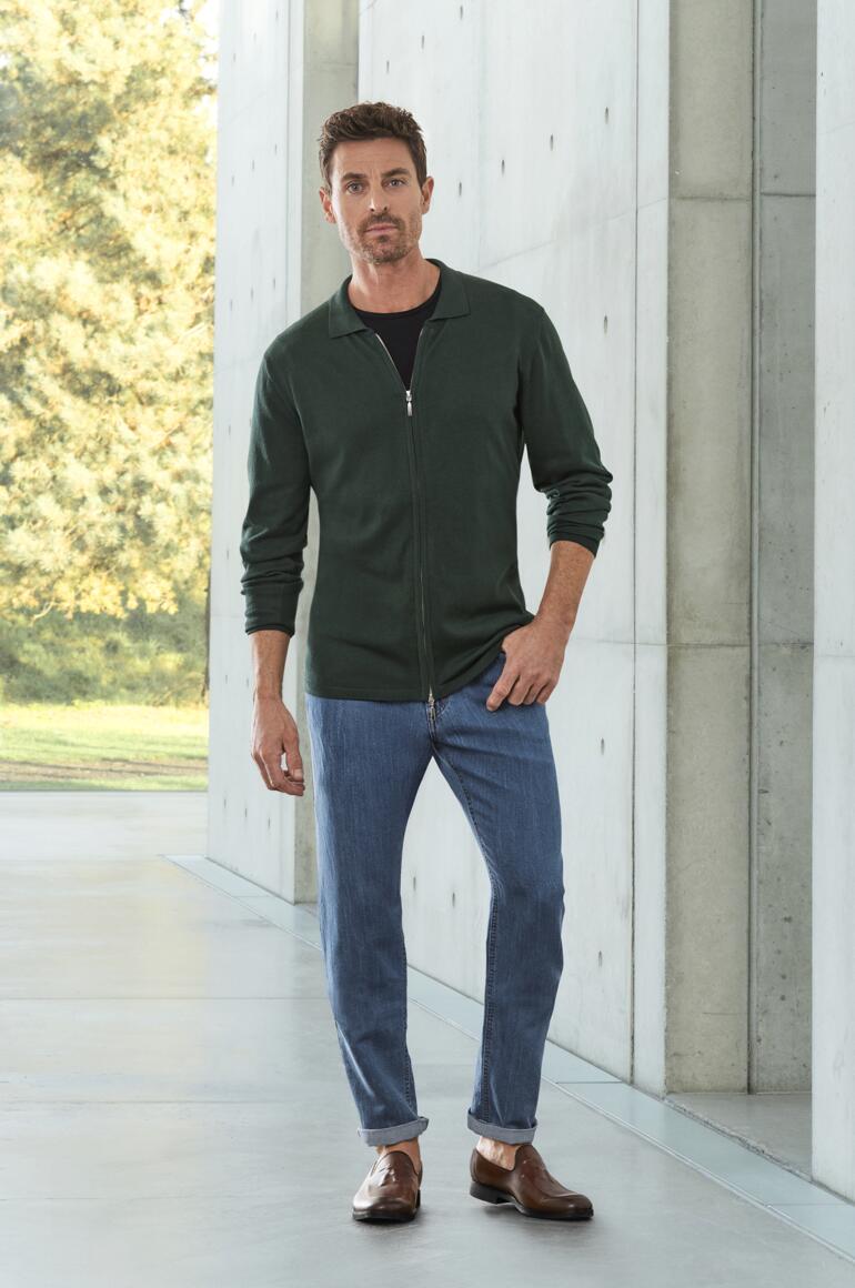 Mocassins à pompons OCONI Homme en veste verte et jeans avec des mocassins à pampilles marron.