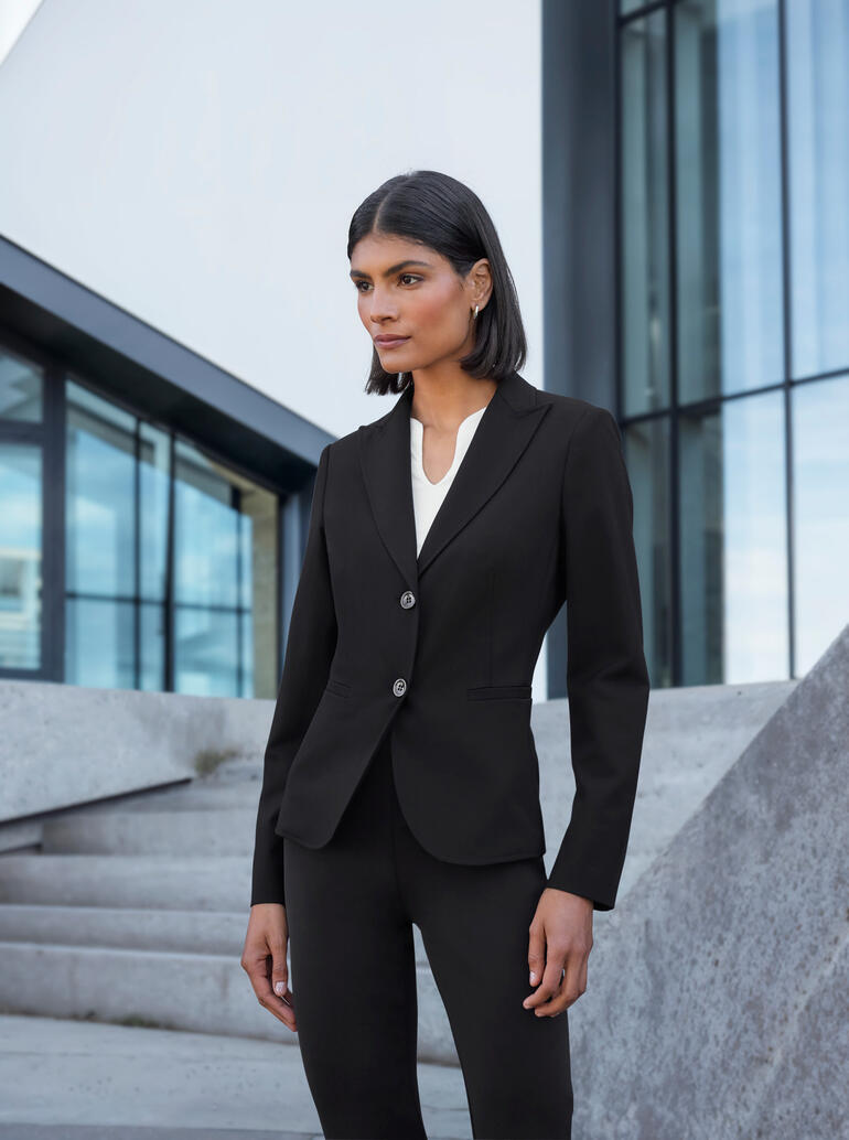 Noir Femme en combinaison blazer élégante devant des bâtiments modernes