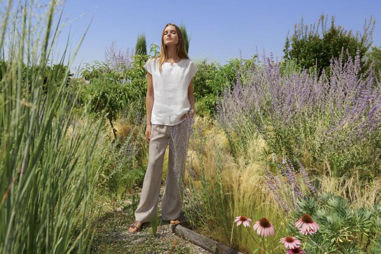 Femme en ensemble loungewear en lin dans un jardin.