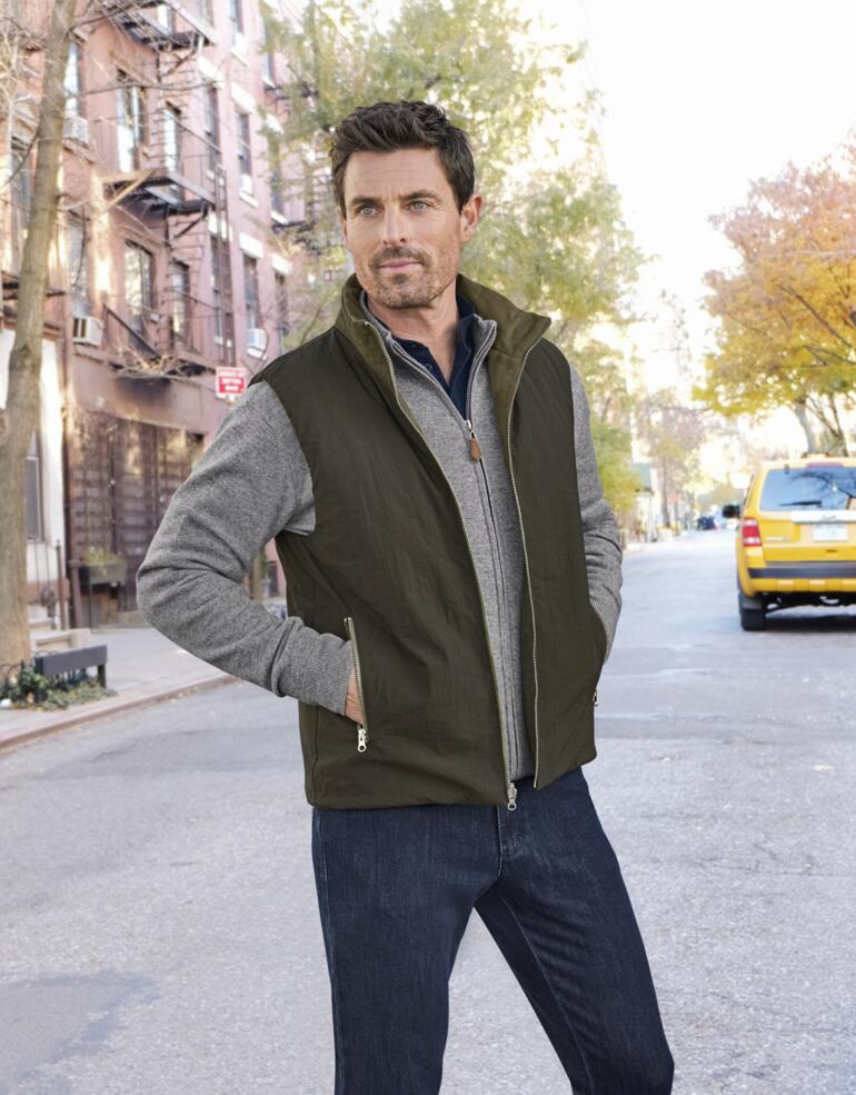 Gilet réversible en suède OCONI Homme portant un gilet réversible olive dans une rue de la ville.