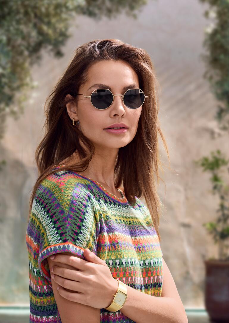 Lunettes de soleil pour femme John Lennon Femme portant des lunettes de soleil rondes John Lennon et un haut coloré