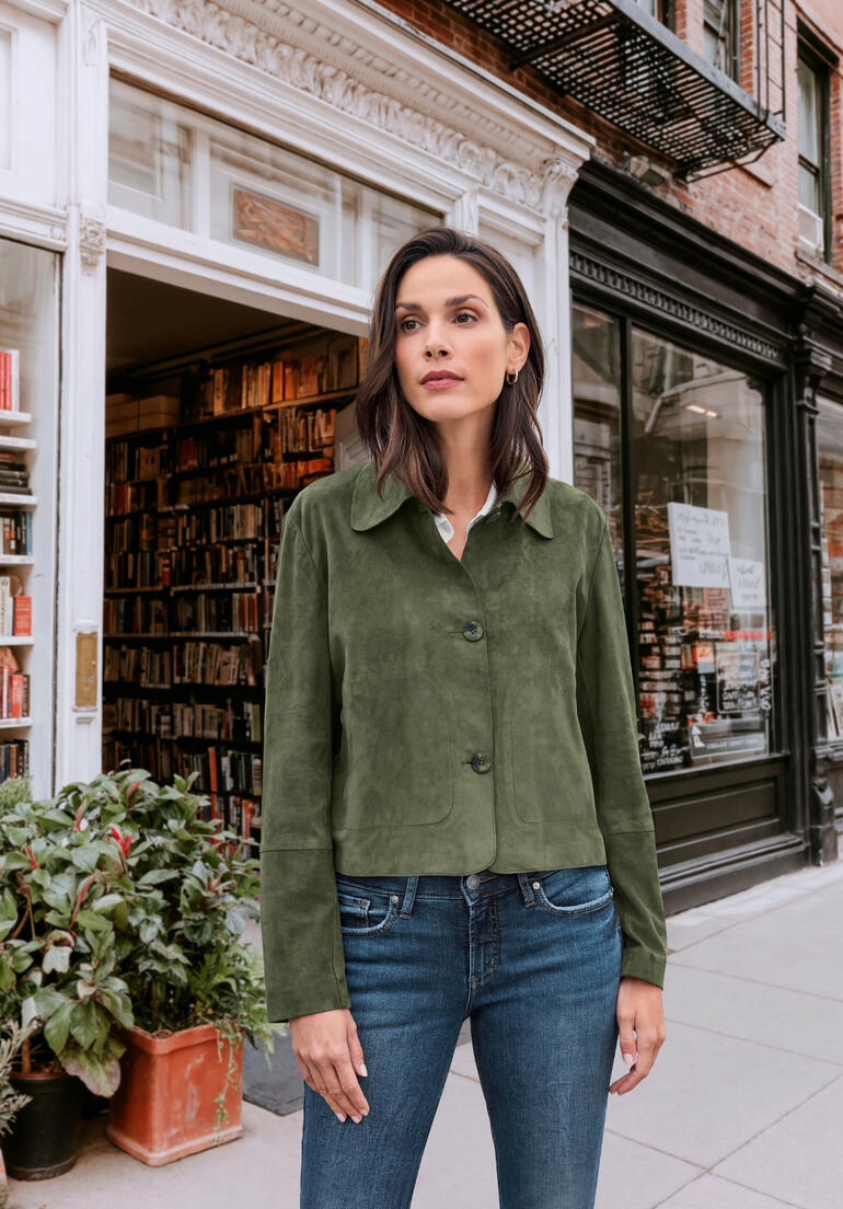 Femme portant une chemise en cuir de chèvre verte devant une librairie