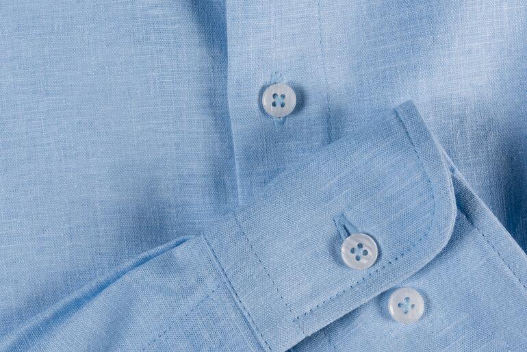Chemise en lin bleu clair avec boutons, gros plan.
