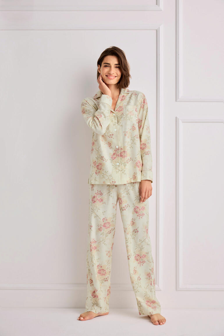 Femme en pyjama florale Ralph Lauren se tenant dans une pièce claire.