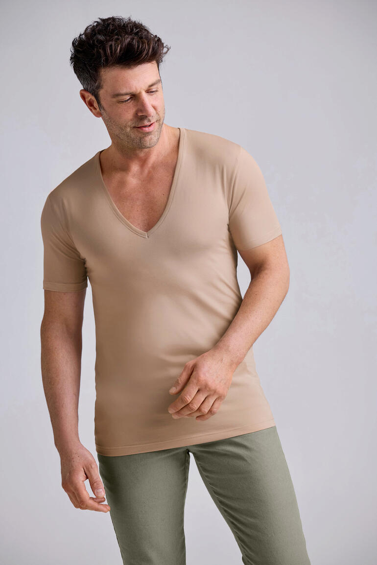 Homme portant un sous-vêtement beige avec un décolleté en V.
