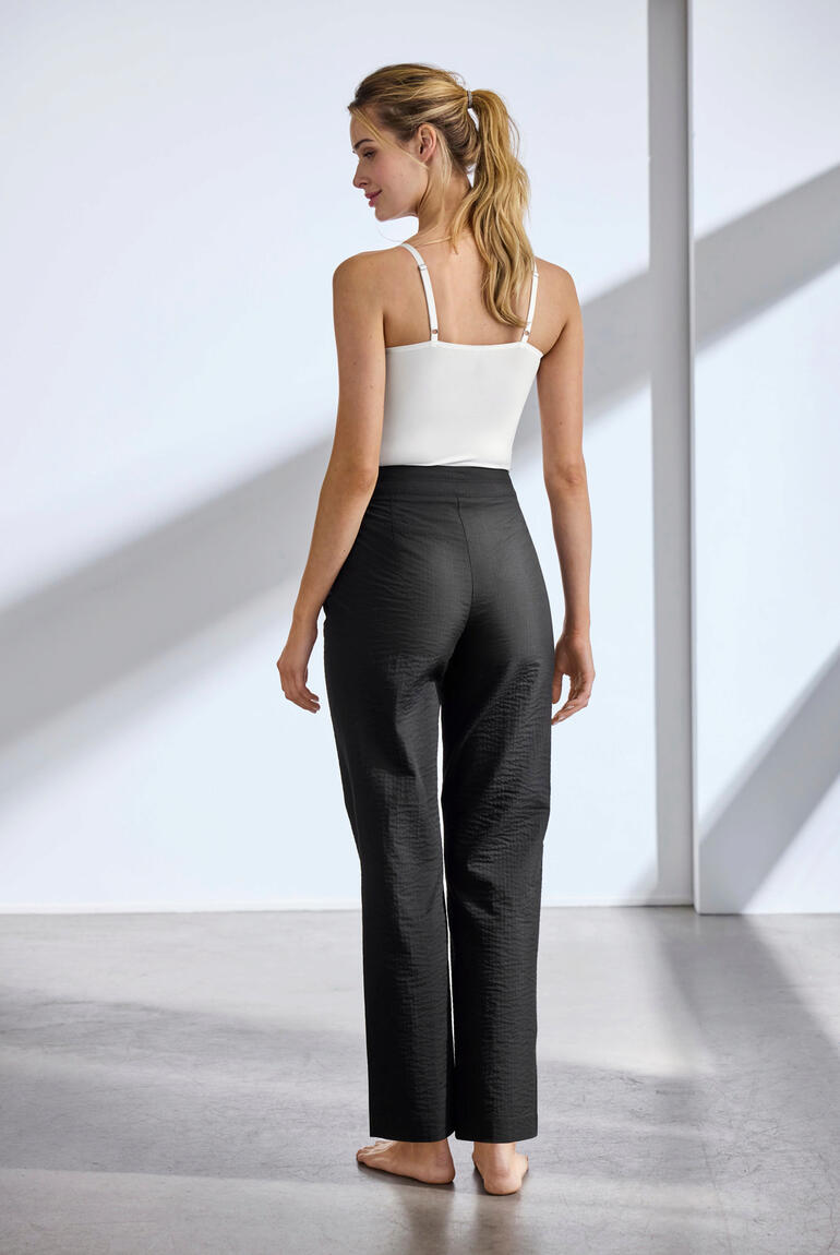 Noir Femme en pantalon d'été noir, vue de dos.