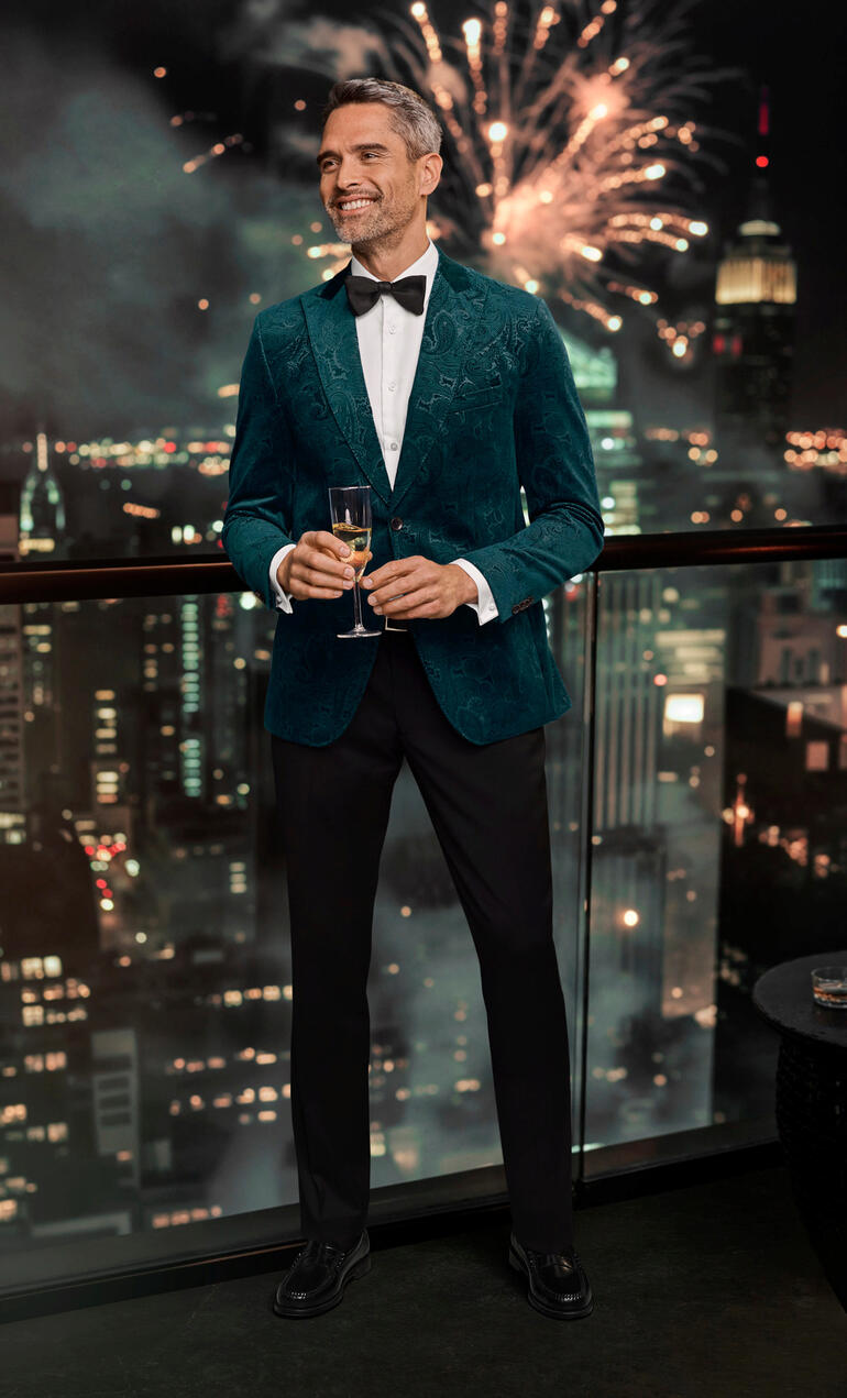 Veste en velours Paisley Carl Gross Homme en blazer en velours paisley vert avec vue sur la ville.
