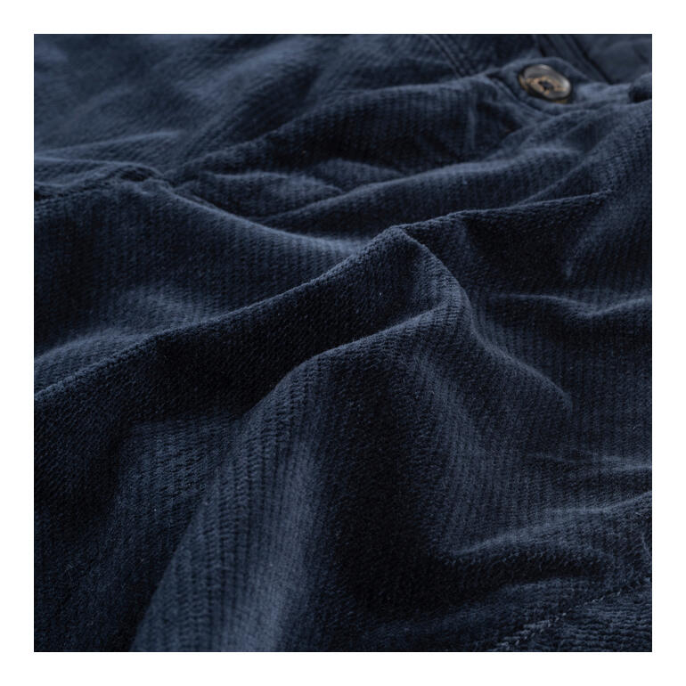 Marine Détail d'un pantalon en velours bleu avec une texture fine.