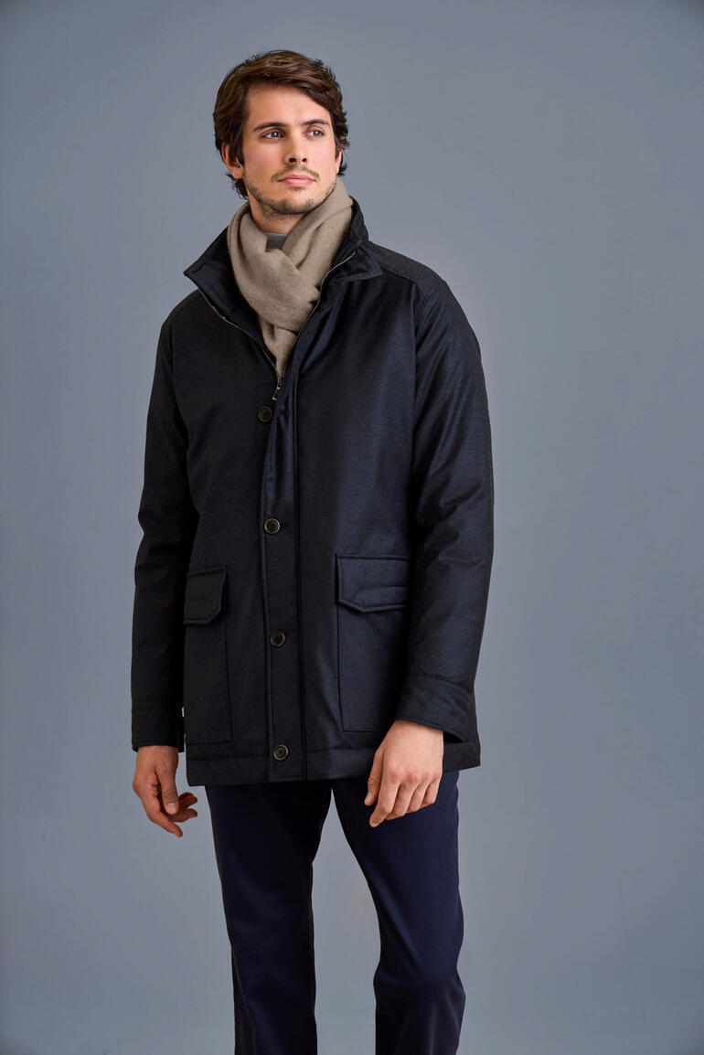 Manteau Storm-System® Lodenfrey Homme en veste Lodenfrey Storm System® avec écharpe devant un fond gris.