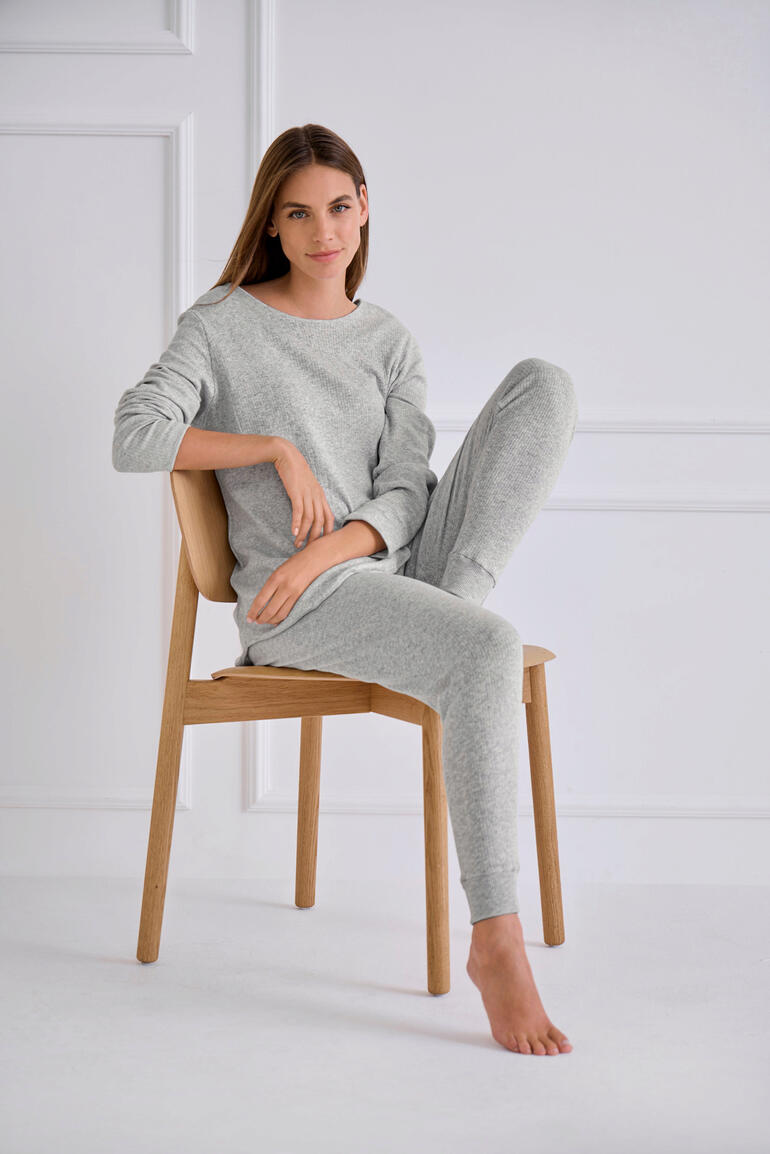 Pyjama Termotex Femme en pyjama grise assise sur une chaise