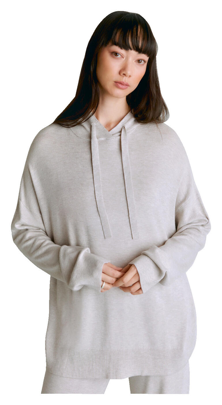 Femme portant un hoodie en lyocell/cachemire gris clair avec capuche sur fond blanc.