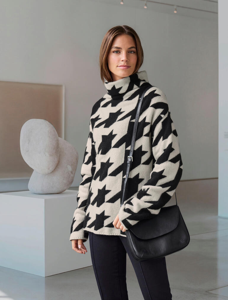 Femme portant un pull en cachemire noir et blanc à motif pied-de-poule