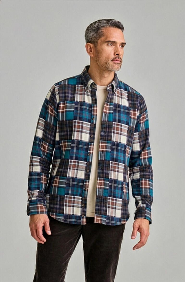 Homme de profil, portant une chemise en flanelle à carreaux bleus avec un t-shirt.