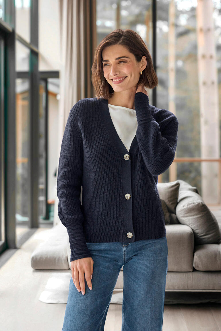 Femme Femme portant un cardigan en cachemire-lin bleu foncé avec boutons.