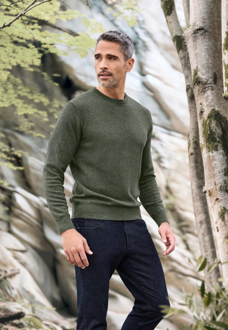 Col rond, Vert Homme portant un pull vert foncé dans un environnement naturel.