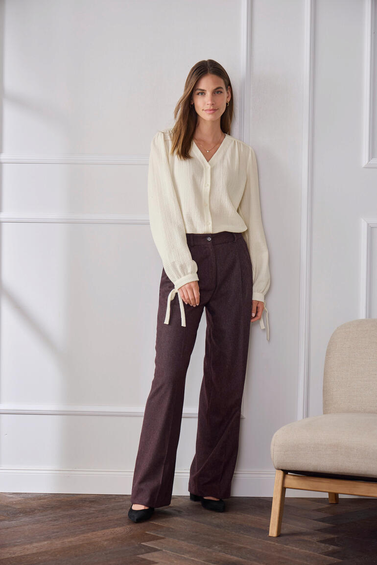 Blouse Crinkle en cachemire et coton Femme debout dans une blouse en coton-cachemire claire à manches longues.