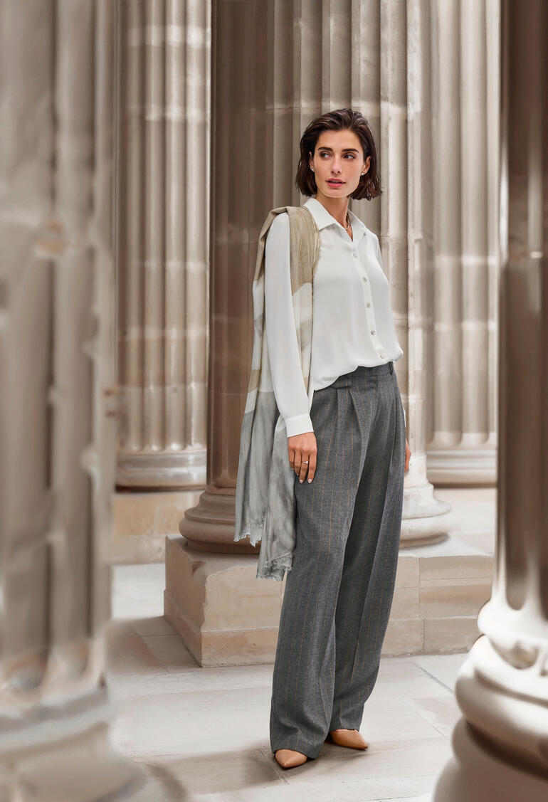 Pantalon à rayures et jambes larges st.Ann Femme en haut clair se tenant entre des colonnes, portant un pantalon long.