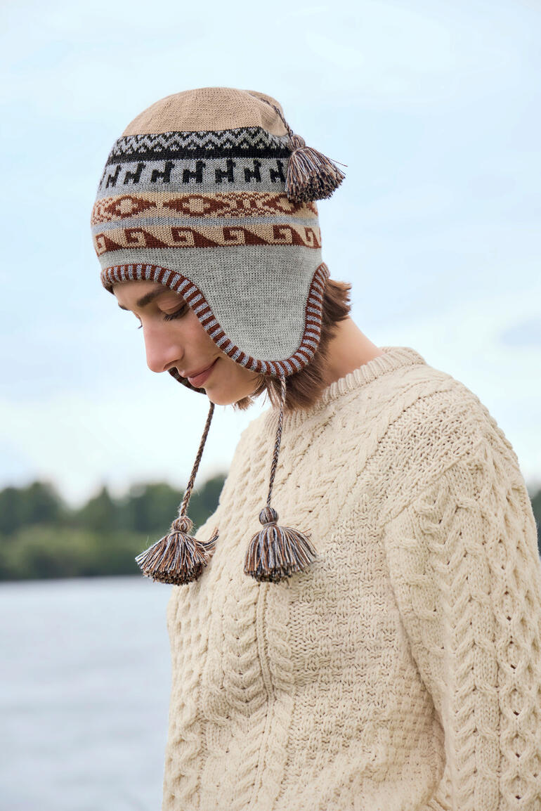 Bonnet péruvien avec motif géométrique et pompons, vue latérale.