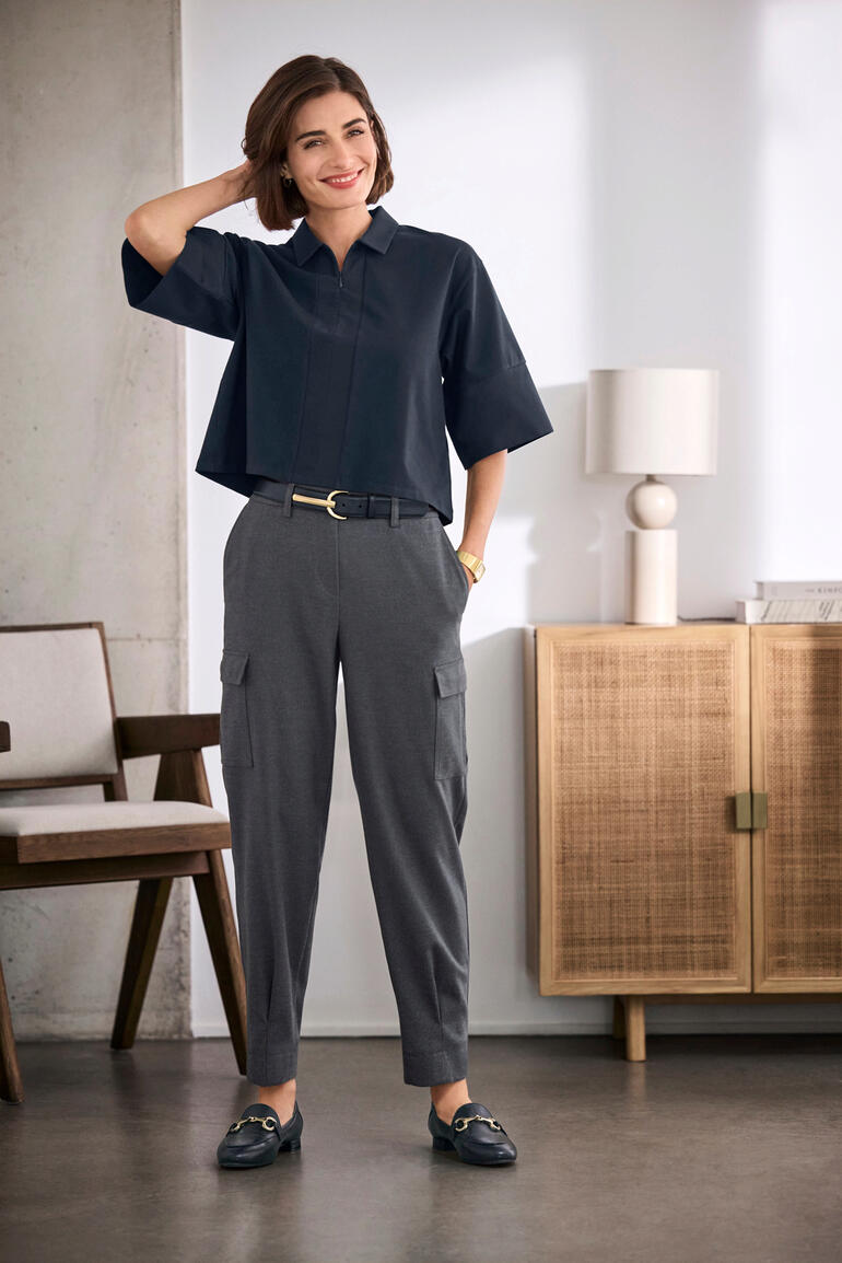 Marine Femme dans une blouse oversize Boxy, associée à un pantalon élégant dans un intérieur moderne.