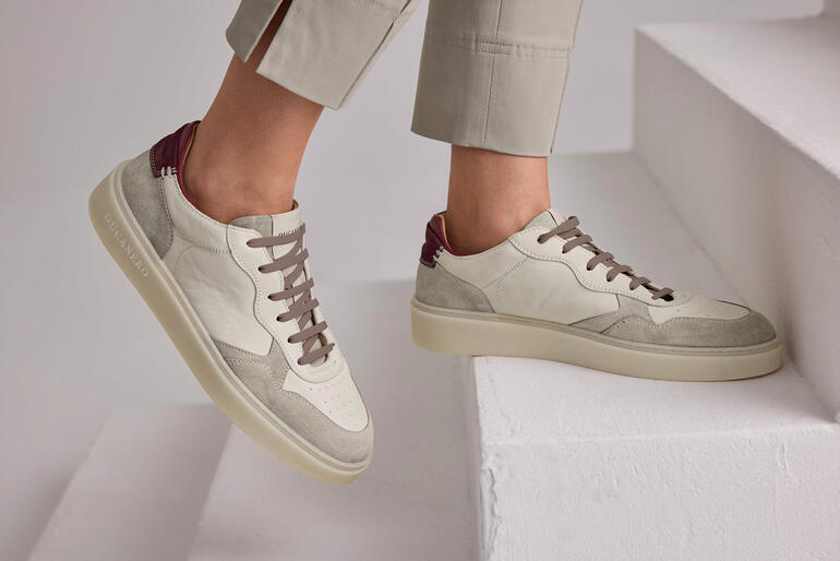 Sneaker beige Ducanero® Basic-Edel, portée par une femme avec un pantalon gris.