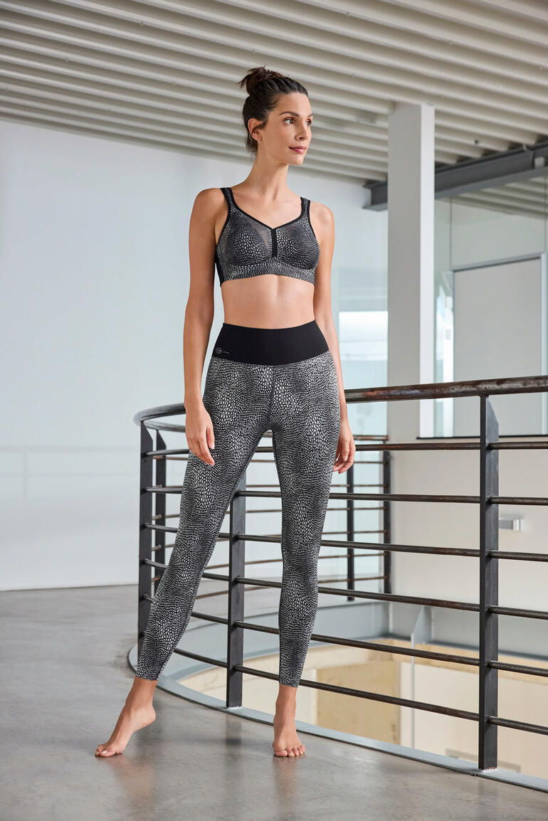 Femme en brassière de sport et leggings dans un intérieur moderne.