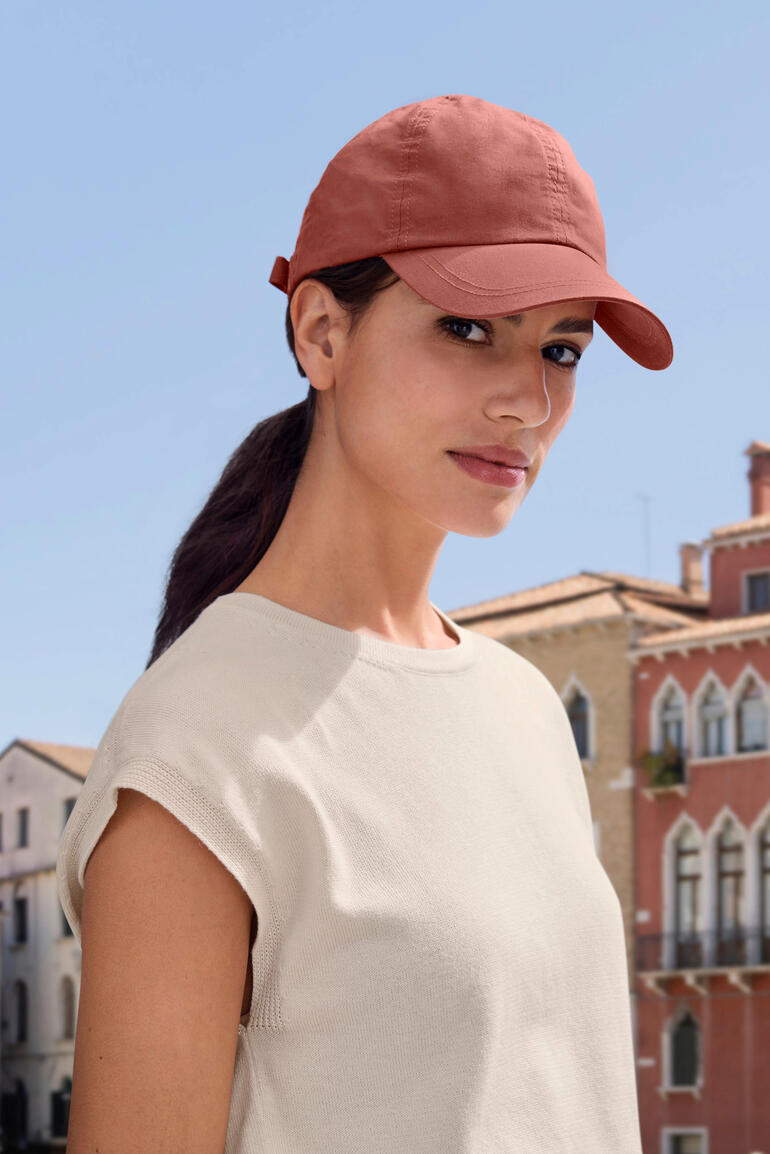 Rouille Femme portant une casquette OCONI couleur rouille à l'extérieur