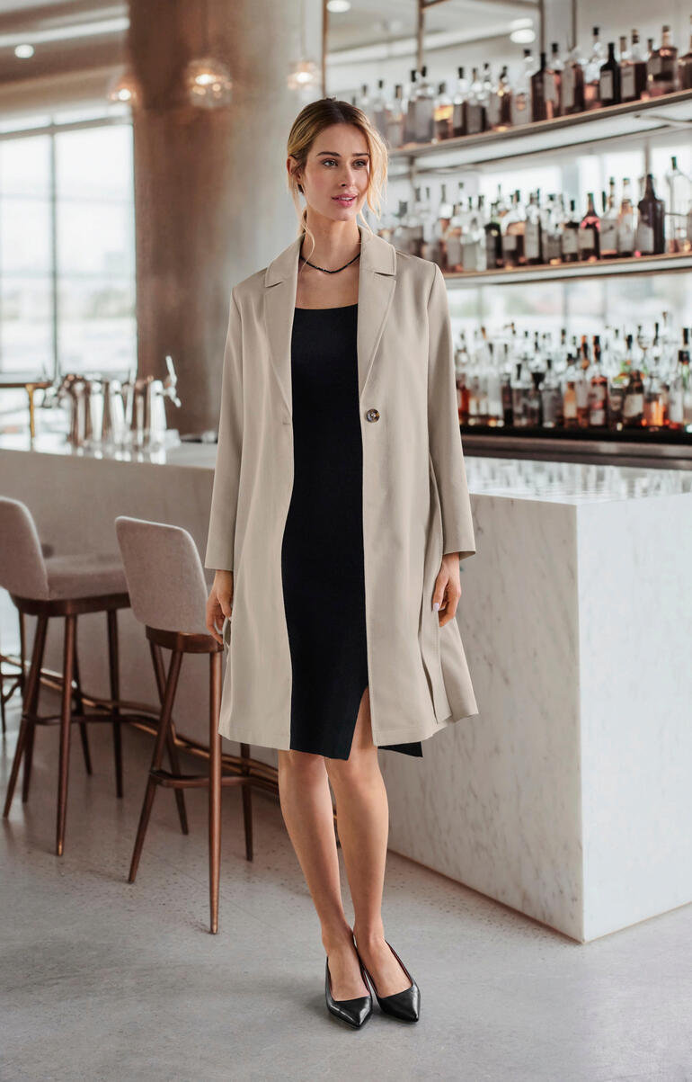 Femme en manteau en alpaga-soie beige dans un bar élégant.