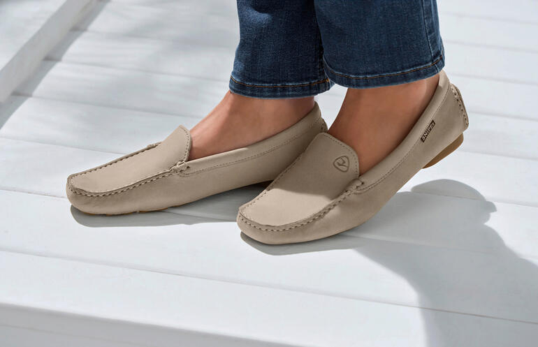 Mocassins en cuir Snipe® beiges, portés par une femme.