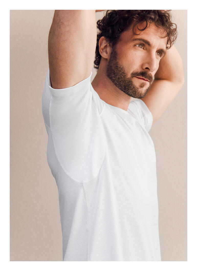 Homme portant un T-shirt blanc de FALKE Daily Climate Control, vue de côté.