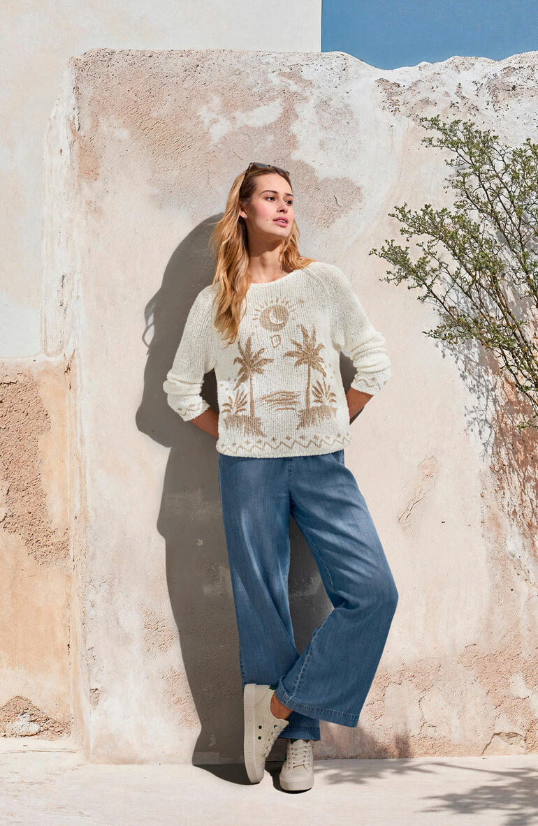 Jeans à jambes larges Bella Dahl Femme portant un pull crème et un jean large bleu clair, devant un mur.