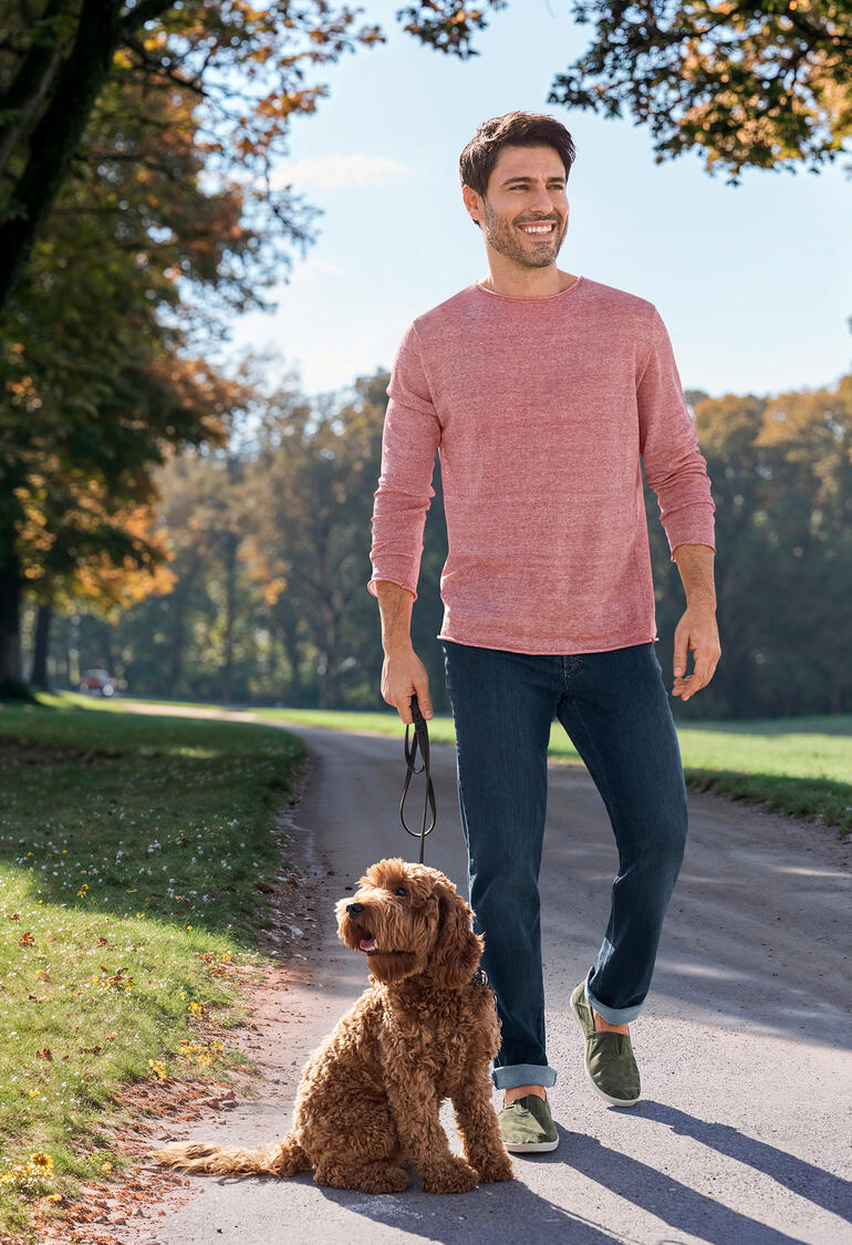 Rouge/Nature Homme en pull léger rose, marchant avec un chien sur un chemin.