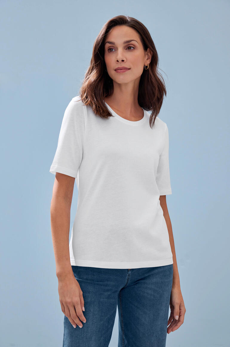 T-shirt en Tencel™ T-shirt blanc en Tencel™ sur un modèle devant un mur bleu.