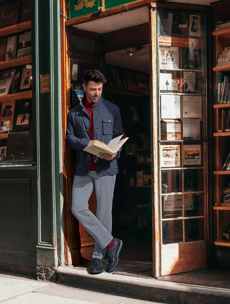 Veste citadine ultra-légère Steinbock® Homme en veste urtra-légère Steinbock® lisant devant une librairie.
